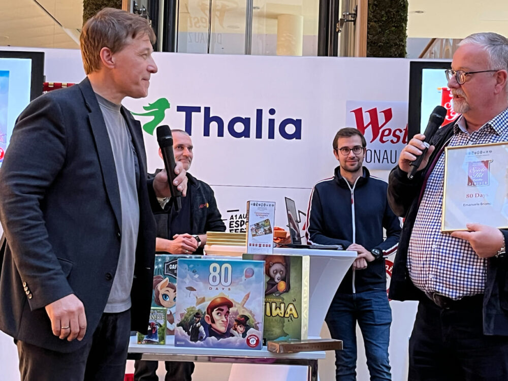 Spieleakademie-Obmann Thomas Bareder überreicht die Auszeichnung für das Top-Familienspiel 
