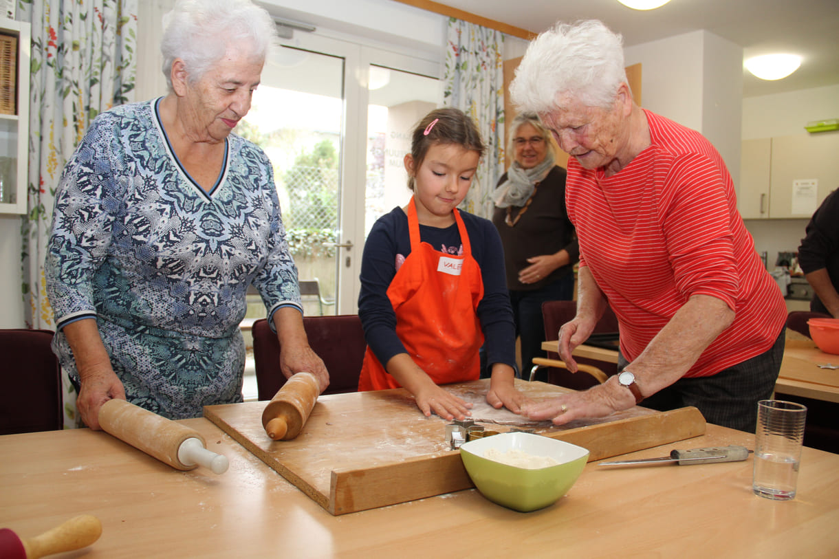 Kindergartenkinder zu Besuch bei AWIK - hier backen sie mit älteren Menschen Kekse bzw. stechen sie aus dem Teig aus