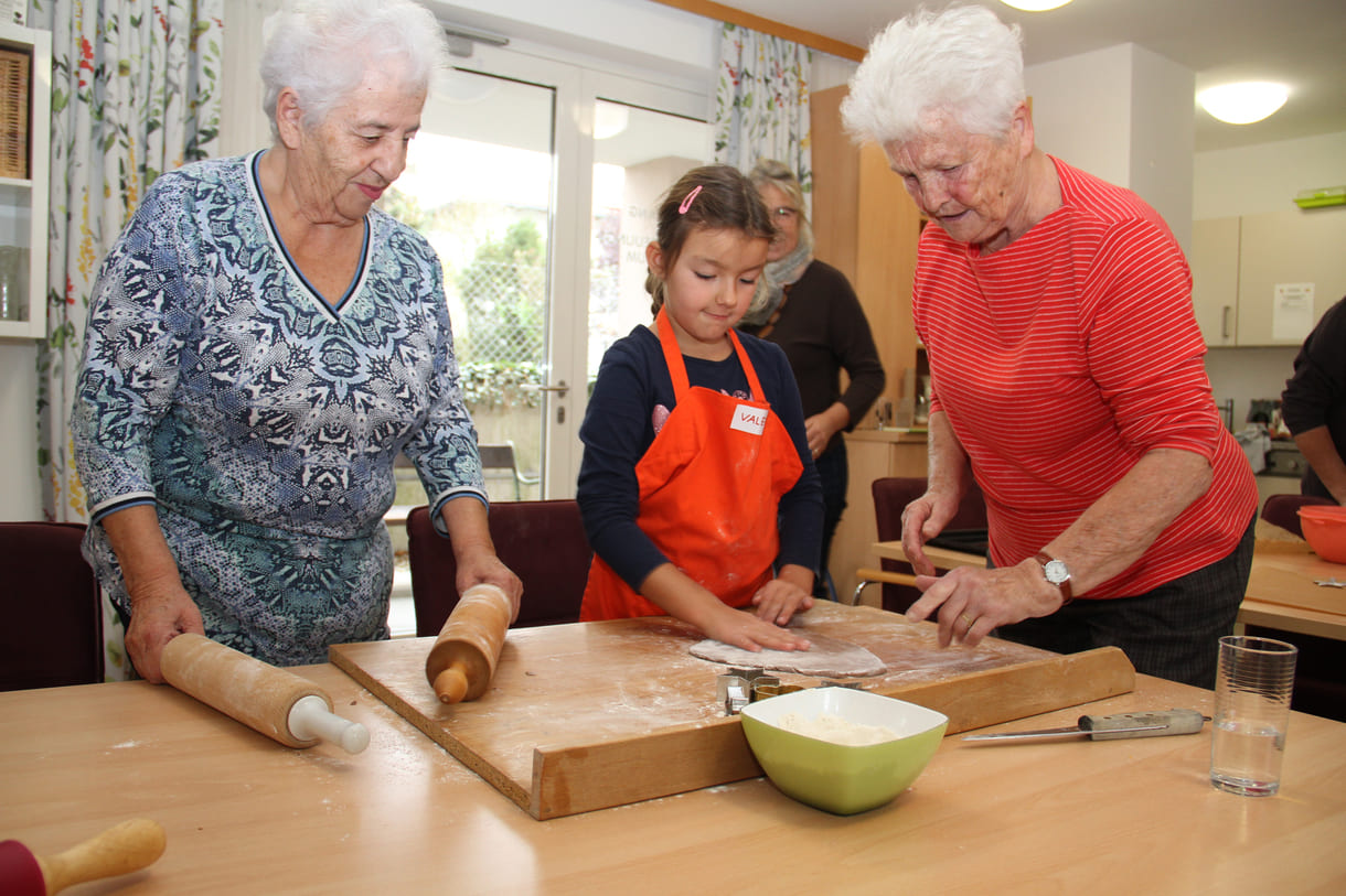 Kindergartenkinder zu Besuch bei AWIK - hier backen sie mit älteren Menschen Kekse bzw. stechen sie aus dem Teig aus