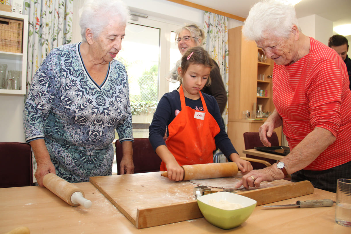 Kindergartenkinder zu Besuch bei AWIK - hier backen sie mit älteren Menschen Kekse bzw. stechen sie aus dem Teig aus