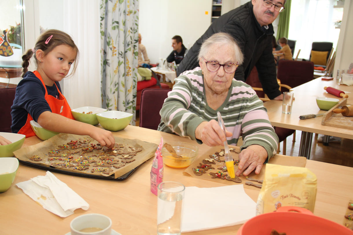 Kindergartenkinder zu Besuch bei AWIK - hier backen sie mit älteren Menschen Kekse bzw. stechen sie aus dem Teig aus