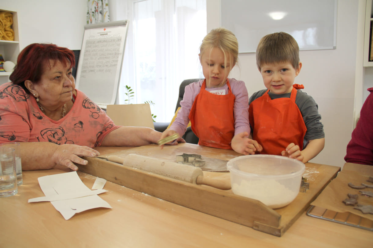 Kindergartenkinder zu Besuch bei AWIK - hier backen sie mit älteren Menschen Kekse bzw. stechen sie aus dem Teig aus