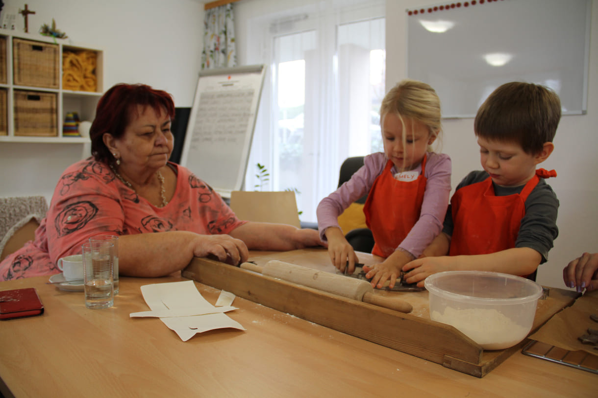 Kindergartenkinder zu Besuch bei AWIK - hier backen sie mit älteren Menschen Kekse bzw. stechen sie aus dem Teig aus