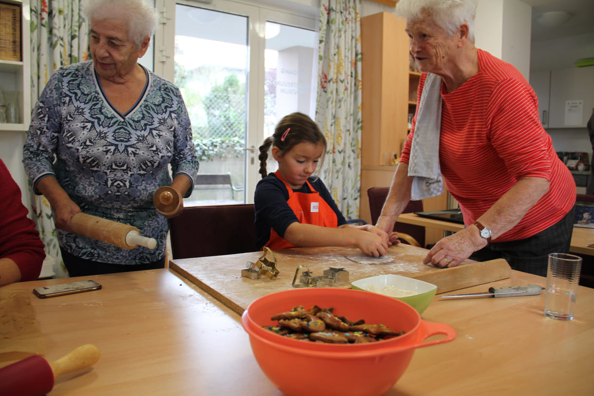 Kindergartenkinder zu Besuch bei AWIK - hier backen sie mit älteren Menschen Kekse bzw. stechen sie aus dem Teig aus