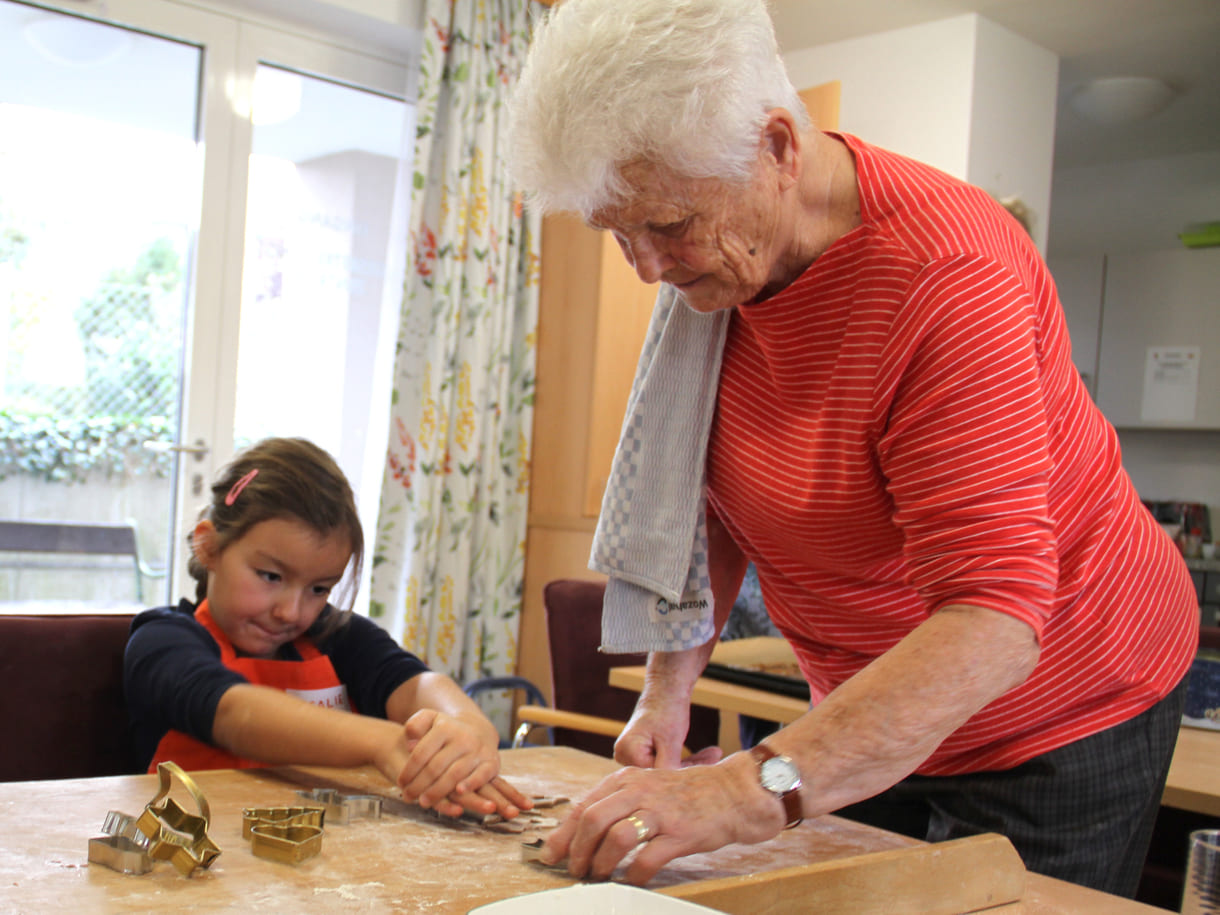 Kindergartenkinder zu Besuch bei AWIK - hier backen sie mit älteren Menschen Kekse bzw. stechen sie aus dem Teig aus