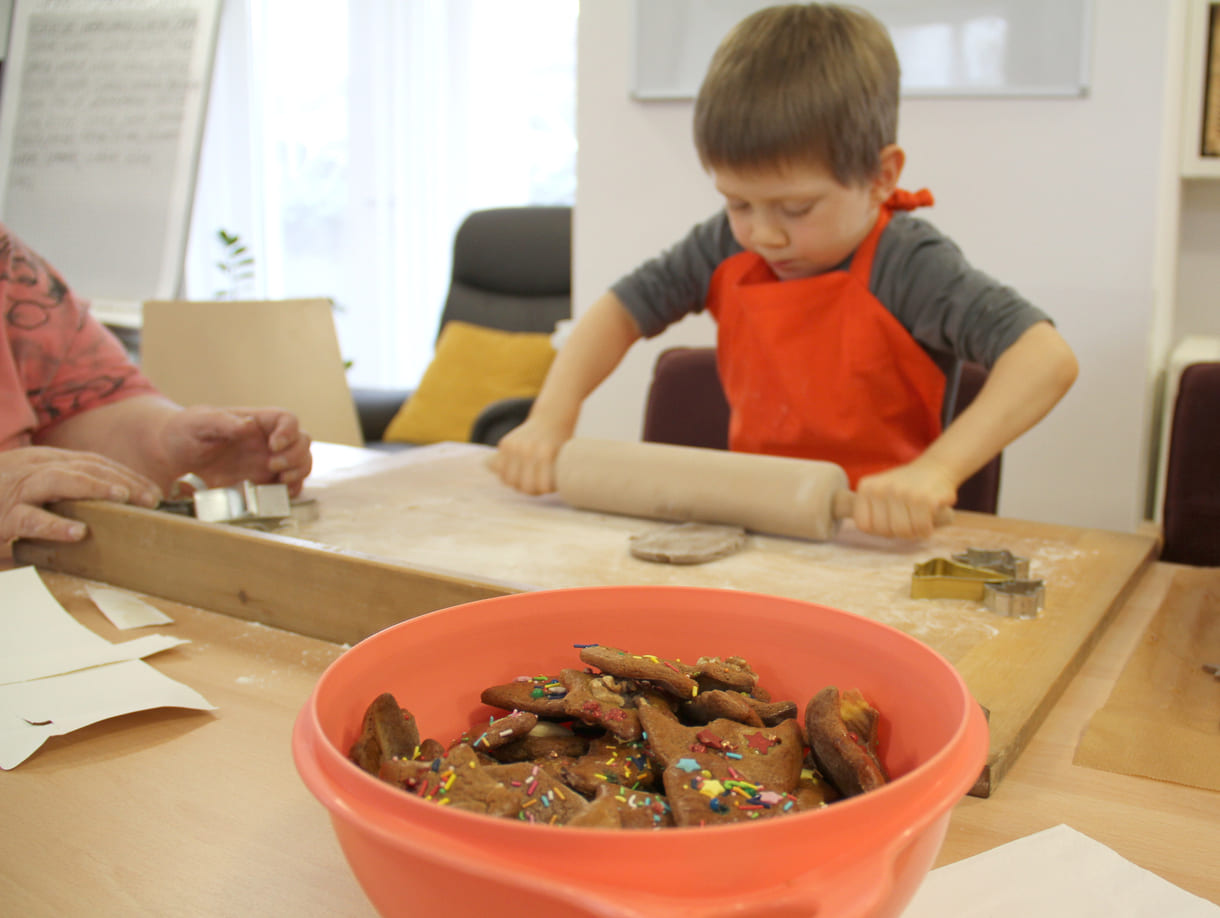 Kindergartenkinder zu Besuch bei AWIK - hier backen sie mit älteren Menschen Kekse bzw. stechen sie aus dem Teig aus