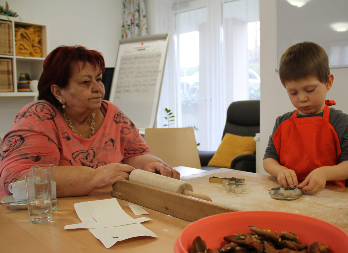 Kindergartenkinder zu Besuch bei AWIK - hier backen sie mit älteren Menschen Kekse bzw. stechen sie aus dem Teig aus