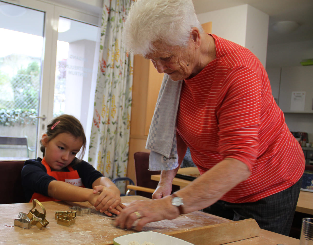 Kindergartenkinder zu Besuch bei AWIK - hier backen sie mit älteren Menschen Kekse bzw. stechen sie aus dem Teig aus