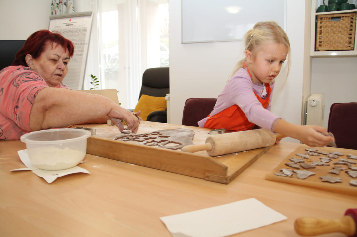 Kindergartenkinder zu Besuch bei AWIK - hier backen sie mit älteren Menschen Kekse bzw. stechen sie aus dem Teig aus