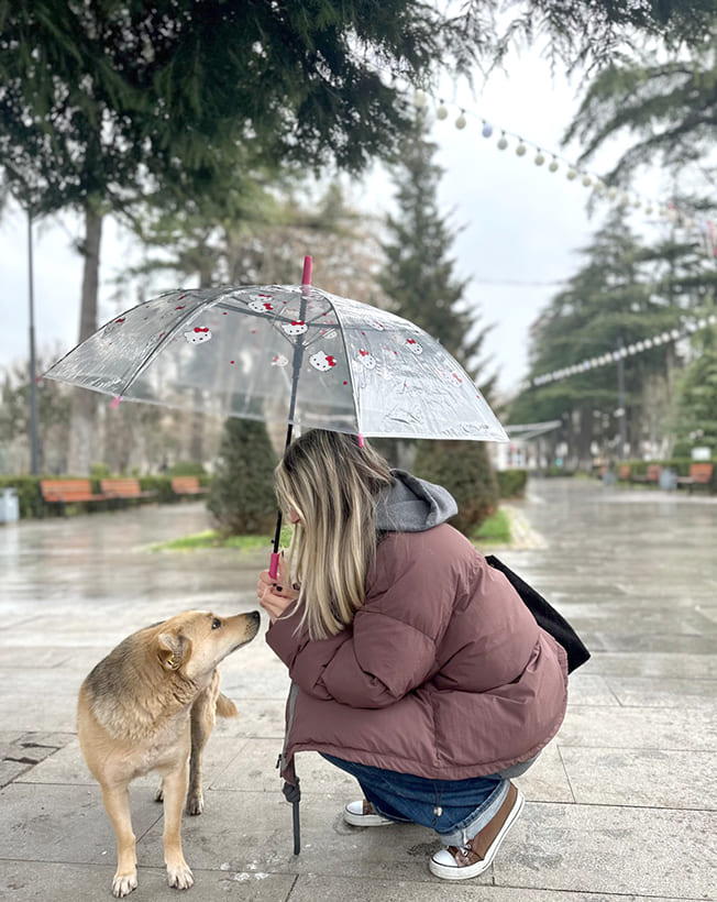 Barbare Narimanashvili fotografierte ihre Schwester, die einen Straßenhund füttert - und beschirmt