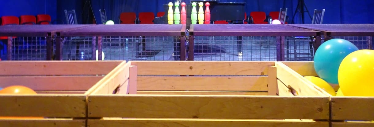 Holzkisten mit bunten Bällen und bunte Kegel im Hintergrund - Bühnenbild für 