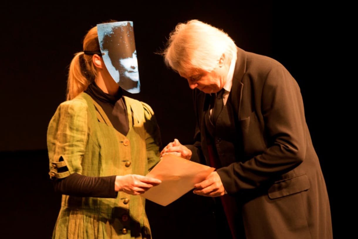 Schauspielerin mit Gesichts-Maske und Schauspieler - Szene aus "Verweigert den Krieg"