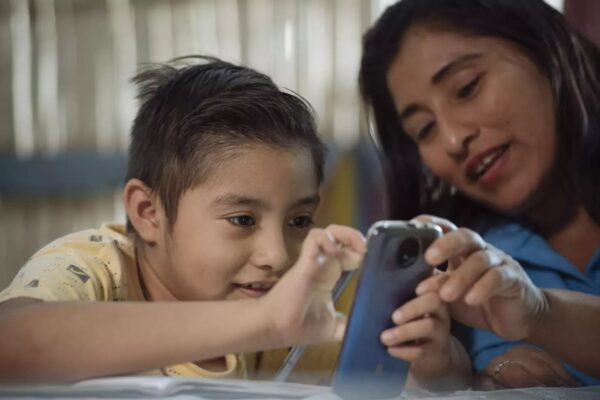 Zwei Kinder schauen in ein Smartphone