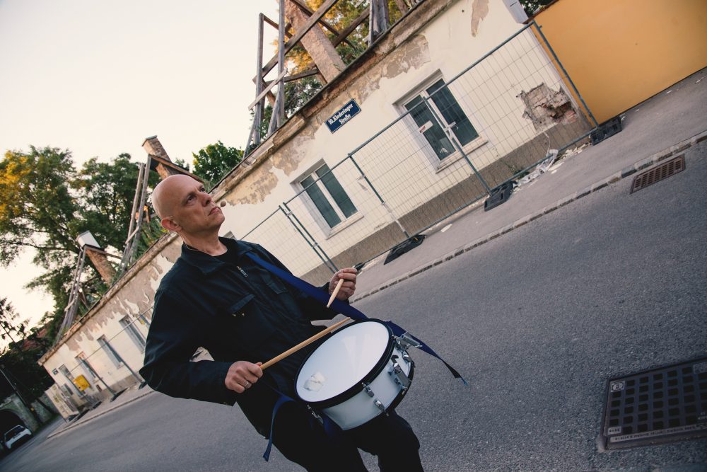 Trommelnder Mann - der Musiker Robert Lepenik - vor einem Abbruchhaus in Wien-Favoriten