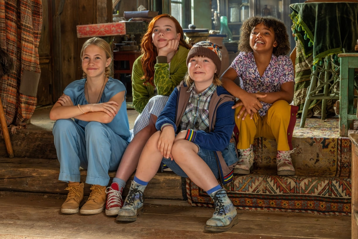 Szenenfoto aus dem Film "Ein Mädchen namens Willow": Die vier Junghexen Valentina (Cora Trube), Willow (Ava Petsch), Gretchen (Anna von Seld) und Lotti (Mary Tölle) (v.l.n.r.) lauschen den Erzählungen des lebendig gewordenen Buches namens Grimmoor