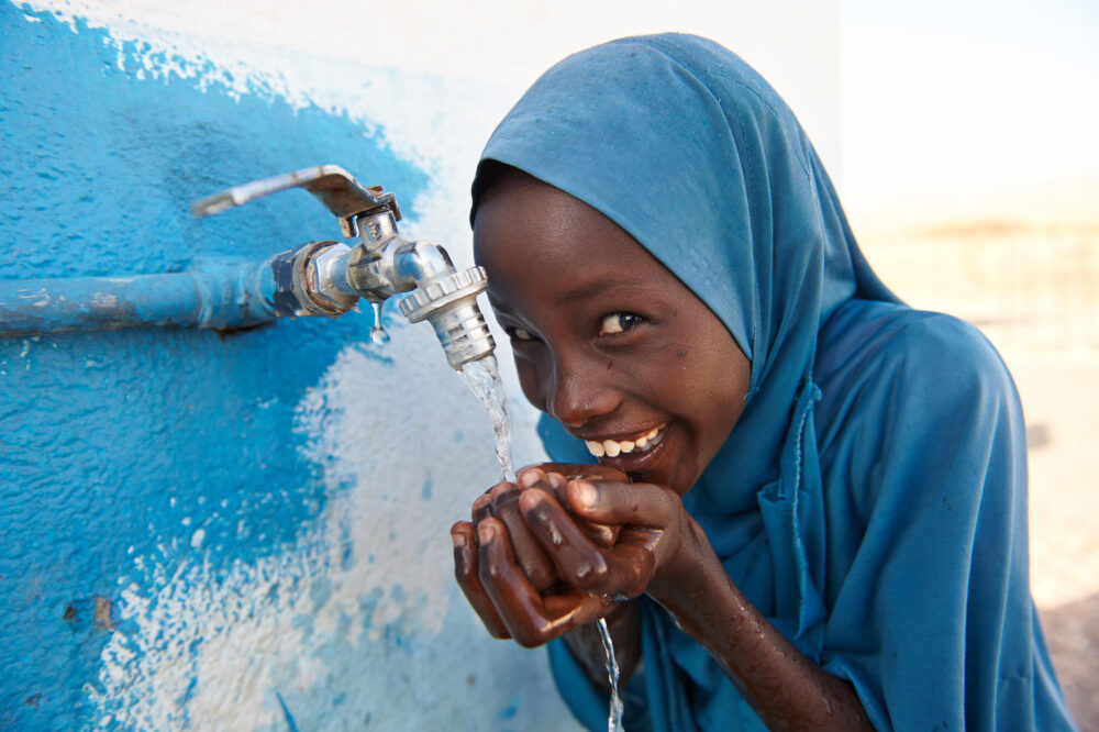 An der Außenmauer einer von UNICEF unterstützten Schule in Dafo bei Tadjourah im Süden Dschibutis, kann dieses Mädchen sauberes Wasser trinken