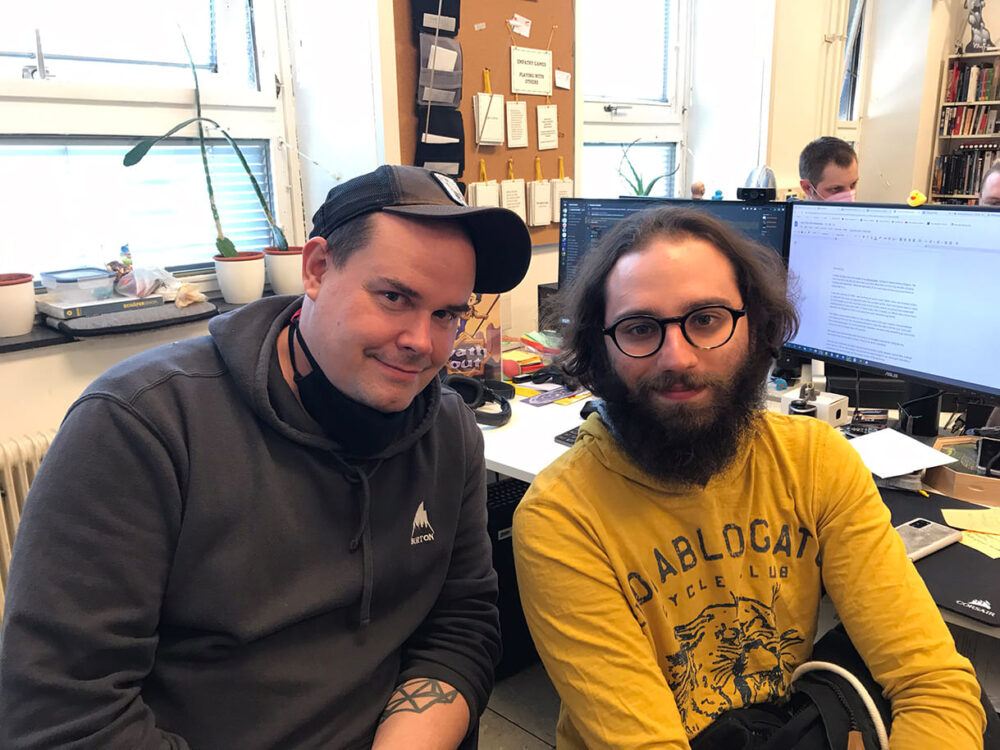 Jack Gutmann im gelben Pulli mit Georg Hobmeier, dem Geschäftsführer von Causa Creations, in ihrem Büro