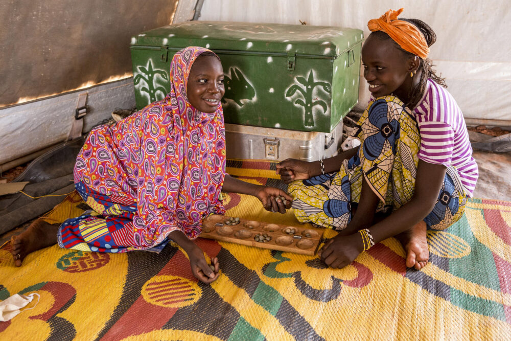 Hawa Gadiaga (links im Bild), die aus ihrem Dorf flüchten musste, spielt in einem von UNICEF unterstützten sicheren Zufluchtszentrum in Mopti (Mali) mit einer Freundin ein traditionelles Spiel