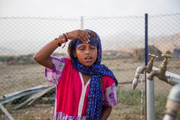 1.207 / 5.000 Die 7-jährige Madina Mohamed Awad steht an einer neuen Wasserstation im kleinen Dorf Gelhanty in der Ortschaft Agig im Bundesstaat Rotes Meer (Sudan) vor sauberem Wasser. Früher hatten Madina und ihre Familie Mühe, an sauberes Wasser zu kommen. Die Ortschaft leidet unter Wasserknappheit und wird häufig von wiederkehrenden Dürren heimgesucht. Die vorhandenen Wasserpumpen trockneten oft aus, wenn der Wasserstand sank. Es war eine Belastung, an sauberes und sicheres Wasser zu kommen. Die einzige verfügbare Wasserquelle war ein Bach, den sie mit Tieren teilten. Das Wasser war unsauber und verunreinigt. Vor kurzem hat UNICEF mit Mitteln von USAID ein solarbetriebenes Wassersystem gebaut, das die Gemeinden im Dorf Gelhanty mit sauberem und sicherem Wasser versorgt.