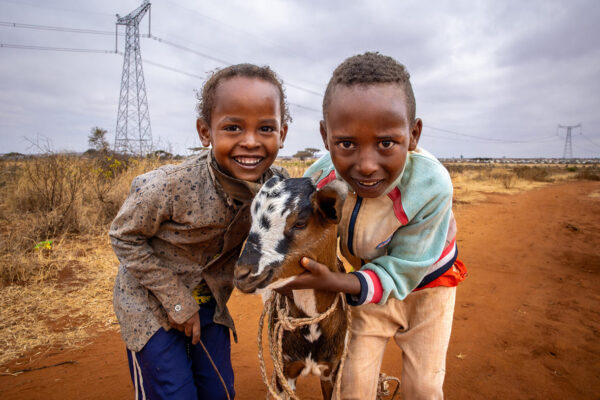 Derara (links) und sein Bruder (rechts) treiben die Ziege, die ihre Eltern kürzlich gekauft haben, zum Grasen hinaus.