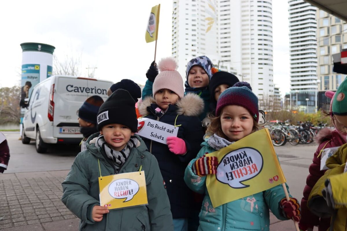 Kinder verteilen Keks und machen auf Kinderrechte aufmerksam