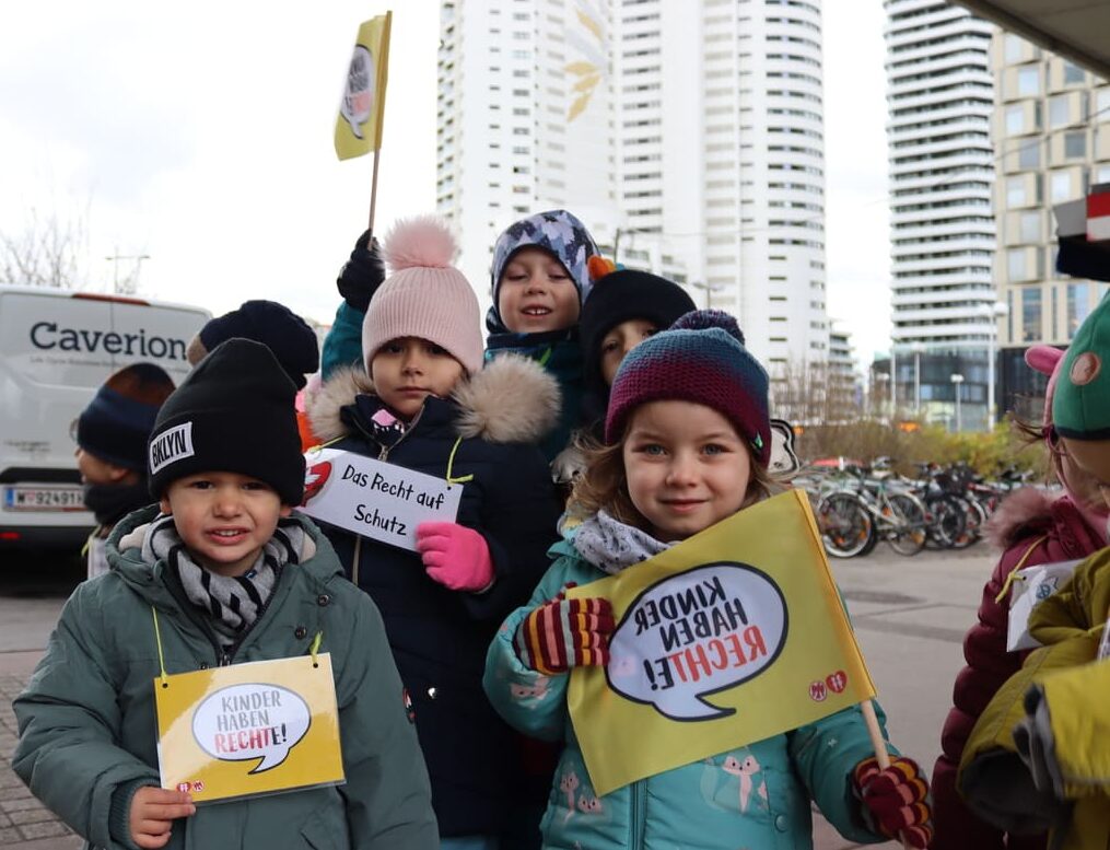 Kinder verteilen Keks und machen auf Kinderrechte aufmerksam