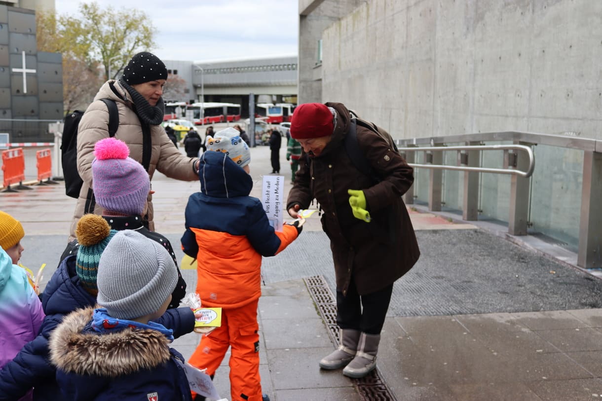 Kinder verteilen Keks und machen auf Kinderrechte aufmerksam