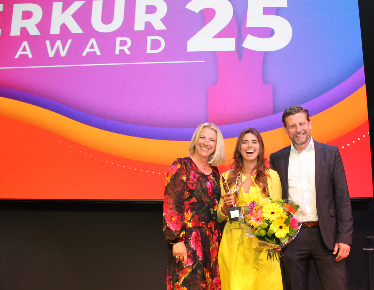 Lachende Merkur-Preisträgerin mit Gratulant:innen
