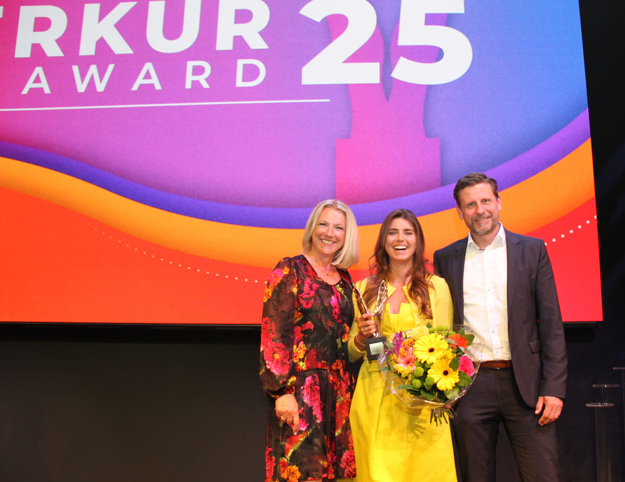 Lachende Merkur-Preisträgerin mit Gratulant:innen
