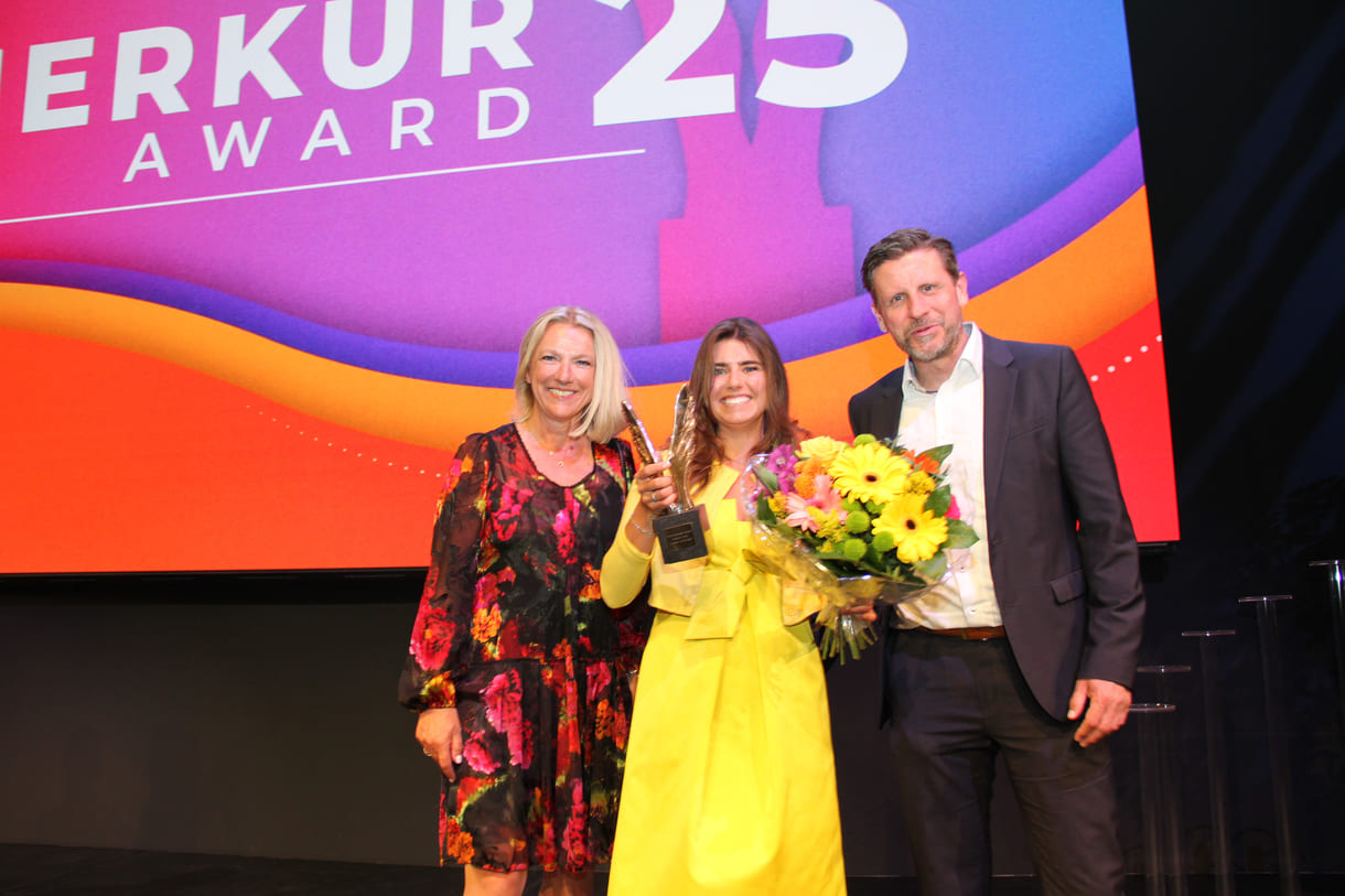 Lachende Merkur-Preisträgerin mit Gratulant:innen
