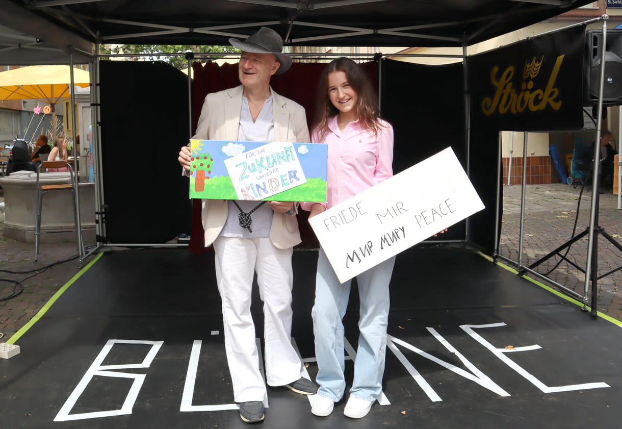 Initiator Gernot Kranner und junge Sängerin Amelie Ricca mit Gemälde und Friedenplakat
