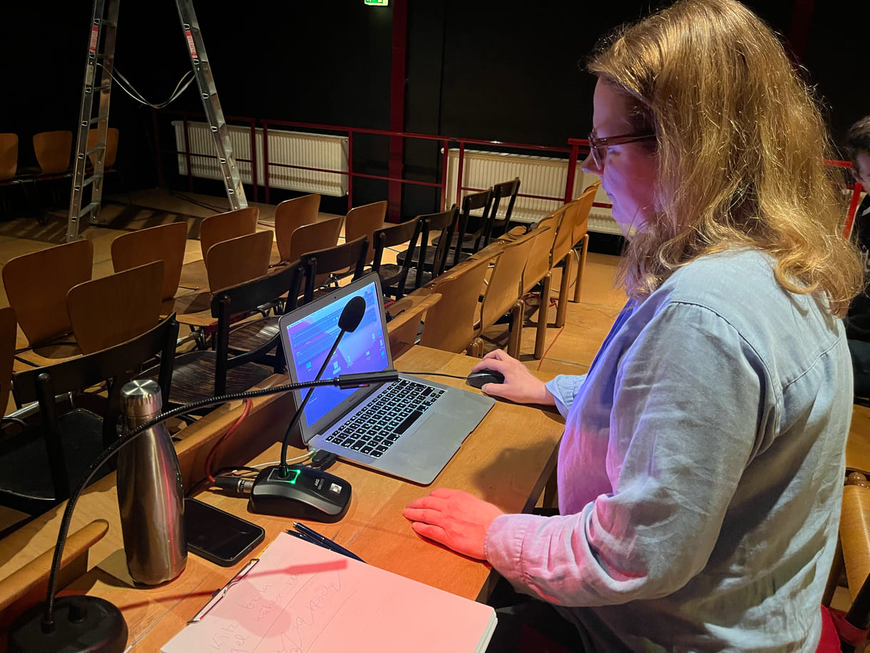 Autorin udn Regisseurin am Laptop vor der Bühne