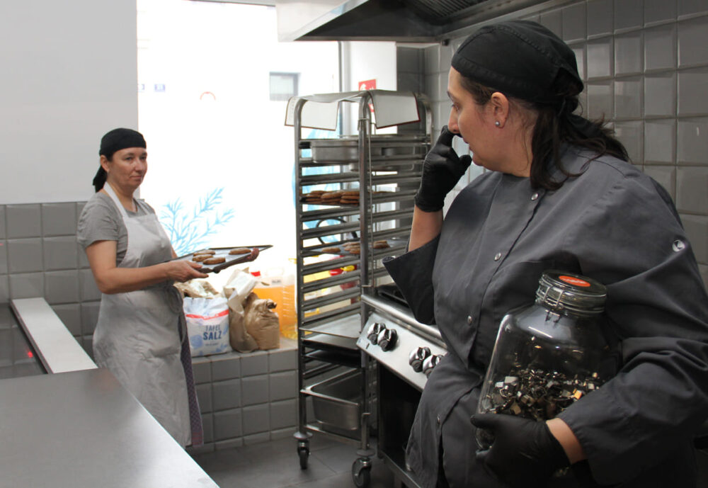Antonia holt die fertig gebackenen Cookies aus dem Regal; rechts im Foto: Claudia, die Erfinderin dieses Business