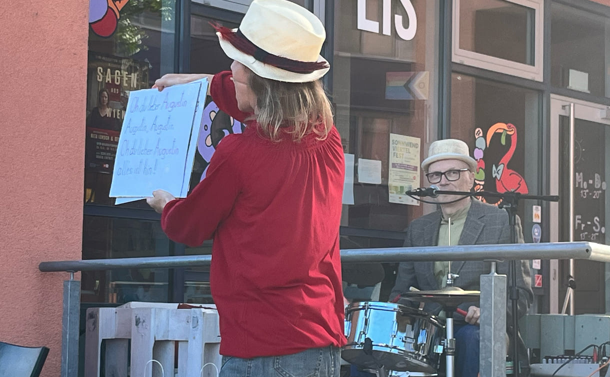 Zum Mitsingen hält die Schauspielerin große Plakate mit dem Text des Liedes 