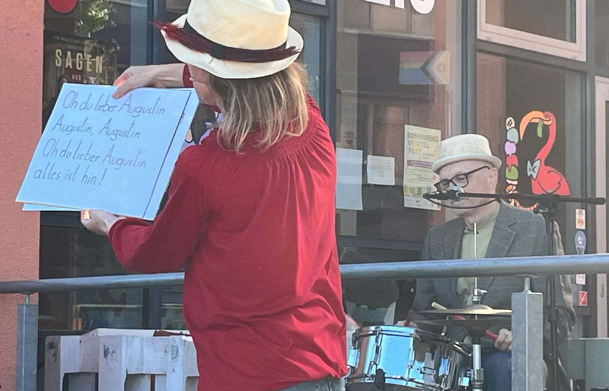Zum Mitsingen hält die Schauspielerin große Plakate mit dem Text des Liedes 