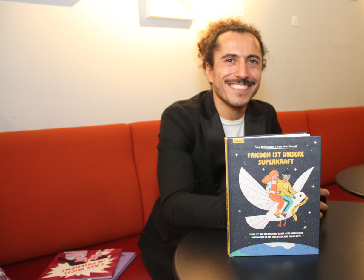 Autor Omar Khir Alanam mit seinem jüngsten Buch "Frieden ist unsere Superkraft"