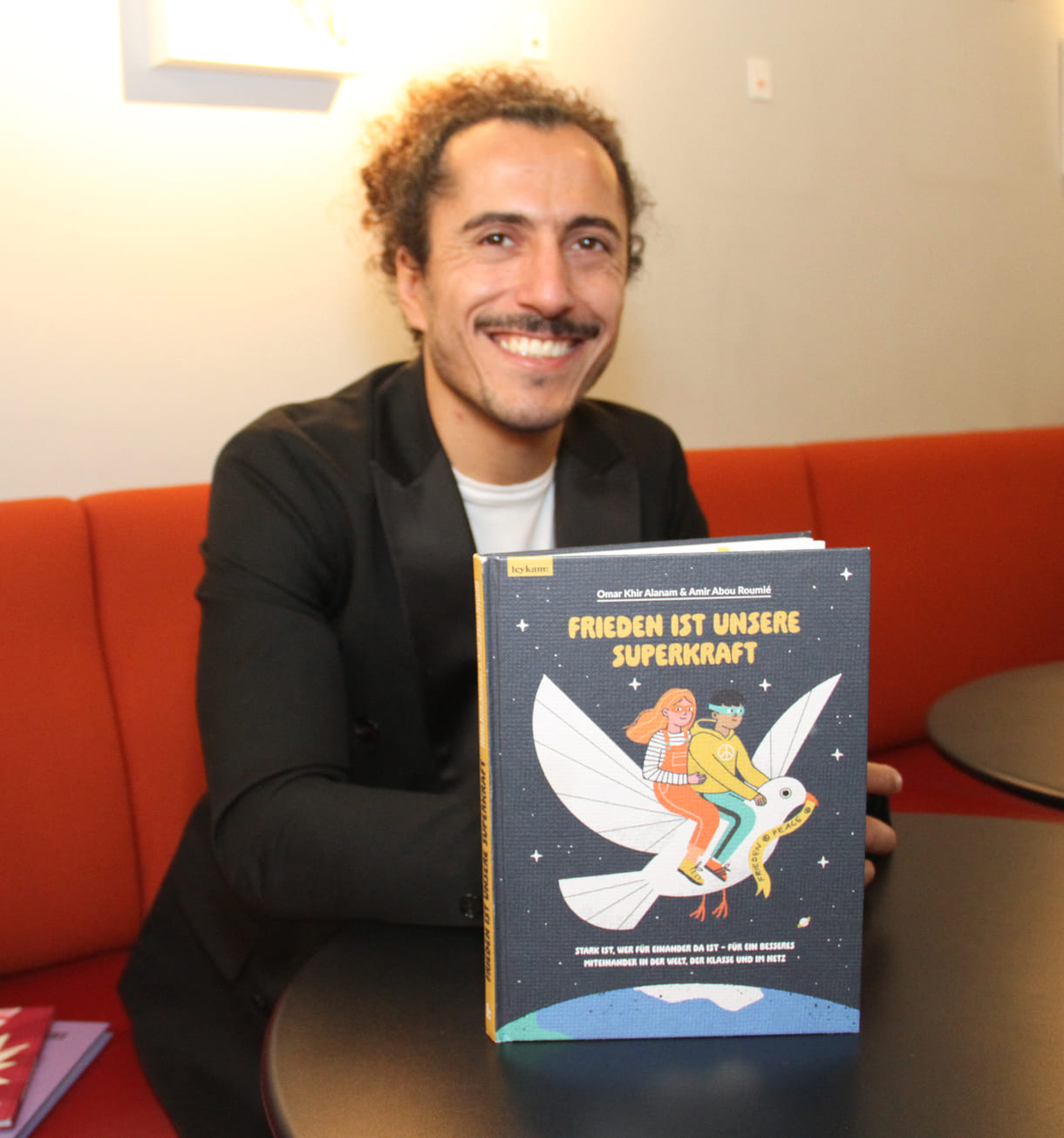 Autor Omar Khir Alanam mit seinem jüngsten Buch "Frieden ist unsere Superkraft"
