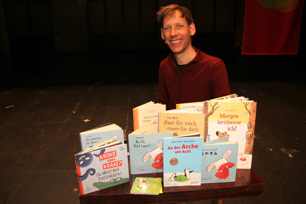 Jörg Mühle mit vielen seiner Bücher, auch einigen der Übersetzungen
