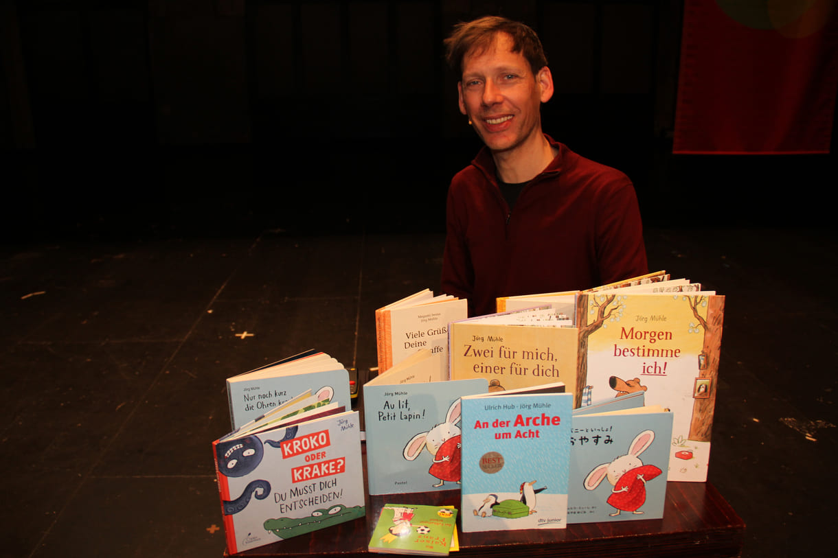 Jörg Mühle mit vielen seiner Bücher, auch einigen der Übersetzungen
