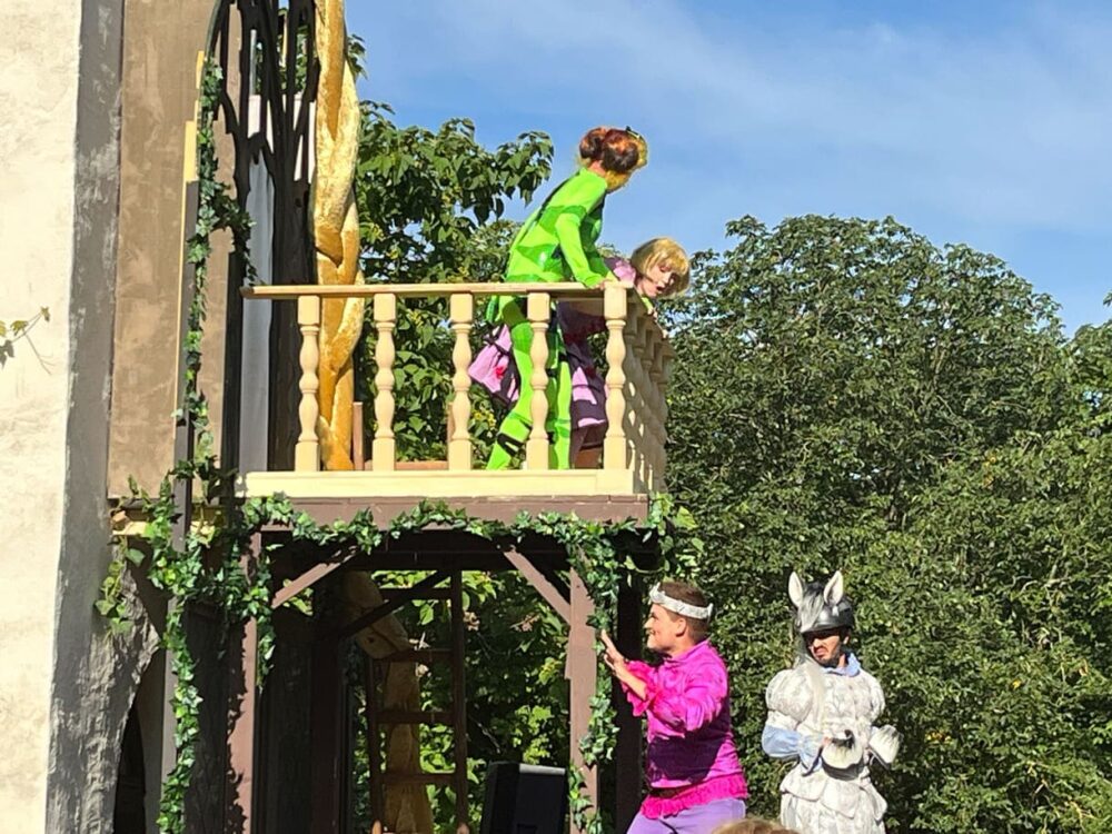Erste Szenen am und unterm Balkon des Turms, in dem Rapunzel gefangen gehalten wird