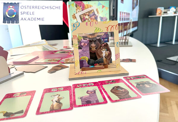 Bild-Montage aus dem neuen Logo des österreichischen Spielepreises und dem Kindespiel des Jahres "Beast Selfies"