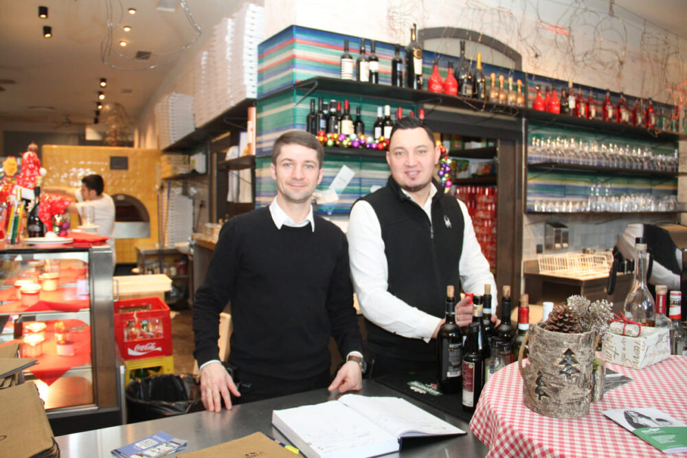 Cosmin und Dawid, Kellner in der Bella Compagnia; im Hintergrund Pizzabäcker Francesco