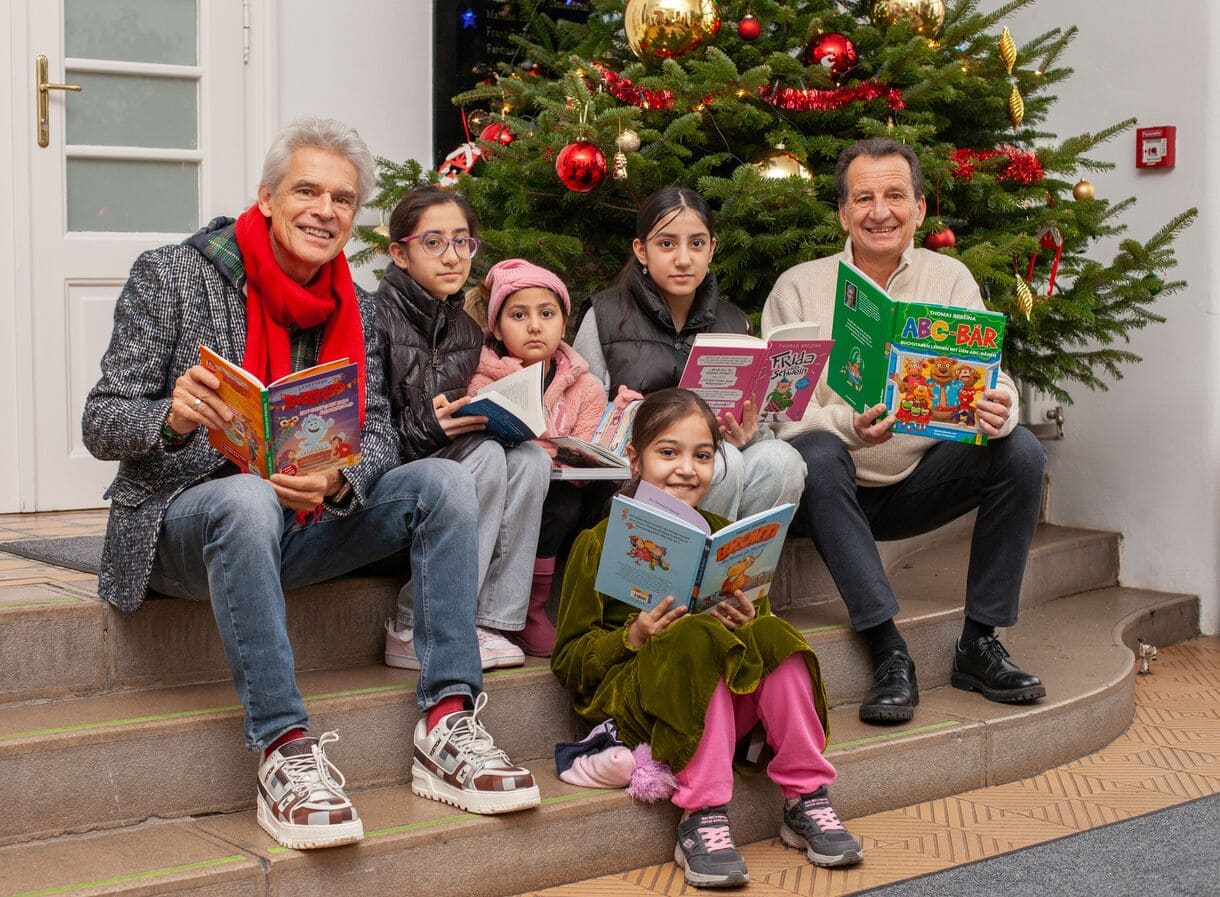 Posieren für ein Gruppenfoto unter und neben dem Weihnachtsbaum