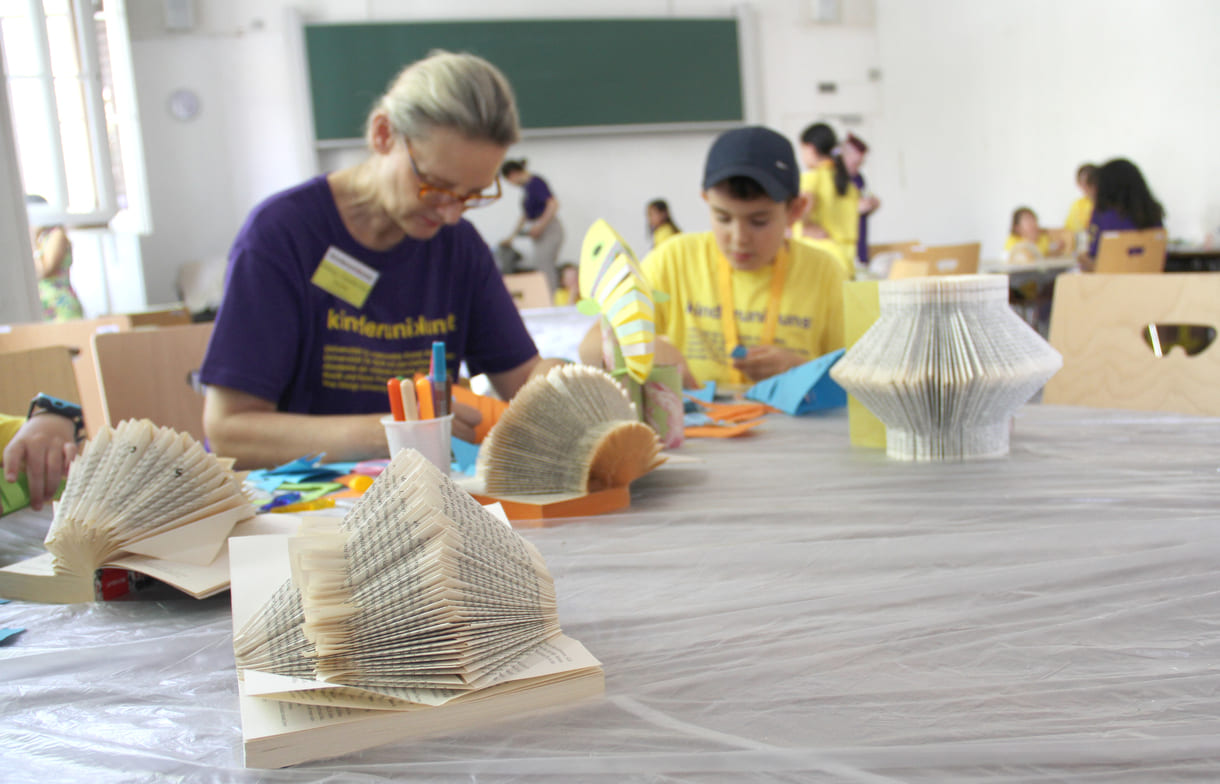 Buchskulpturen und fliegende Papier-Fische