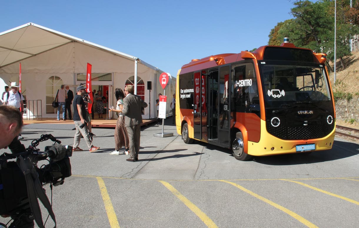 Der autonome Bus neben einem für den Medientermin aufgestellten Zelt