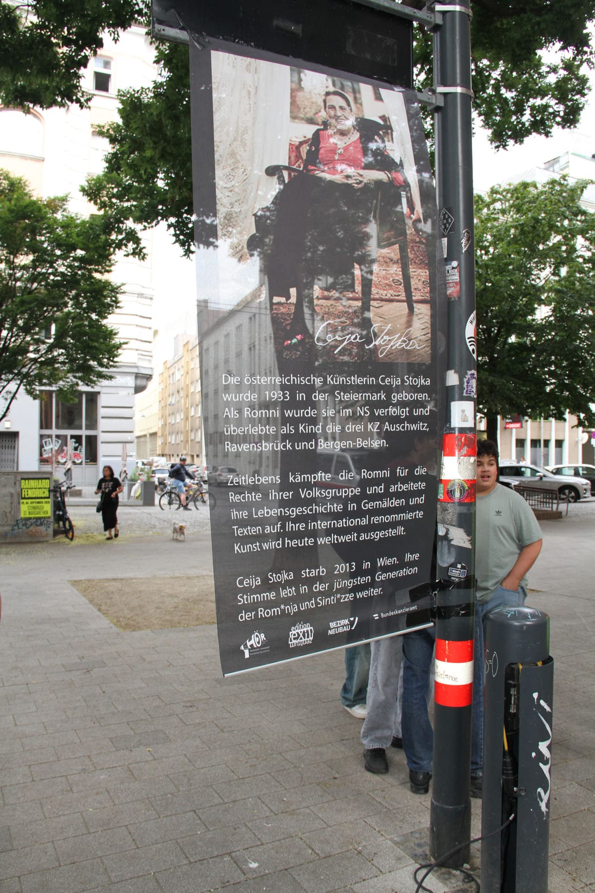 Unter dem Platzschild ein Banner mit Infos zur Namensgeberin Ceija Stojka