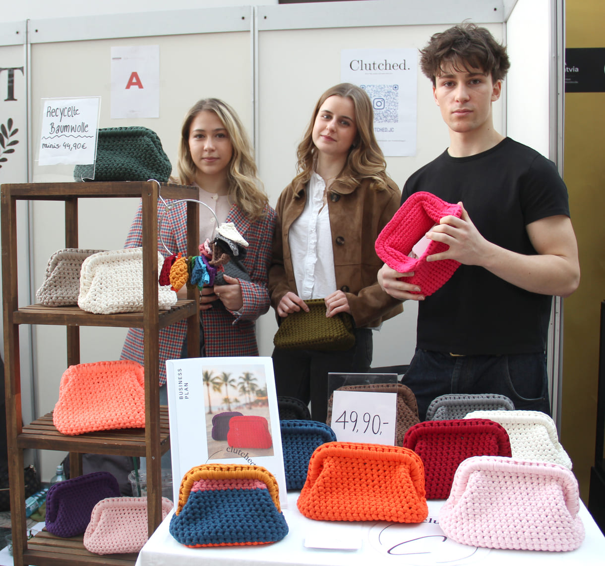 Drei Jugendliche der W@lz (Wiener Alternatives LernZentrum) präsentieren gehäkelte Taschen, teils aus wiederverwendeter (Baum-)Wolle - 