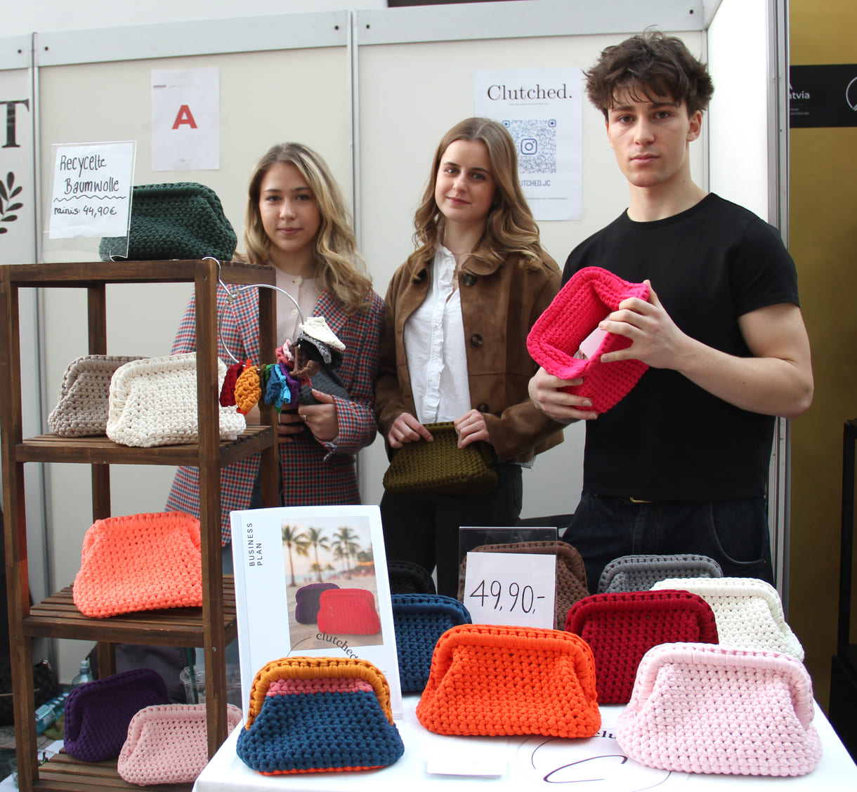 Drei Jugendliche der W@lz (Wiener Alternatives LernZentrum) präsentieren gehäkelte Taschen, teils aus wiederverwendeter (Baum-)Wolle - 