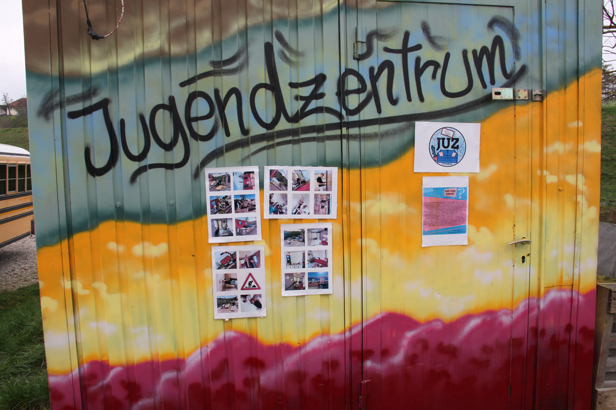 Plakate und Fotos an einer der Container-Wände