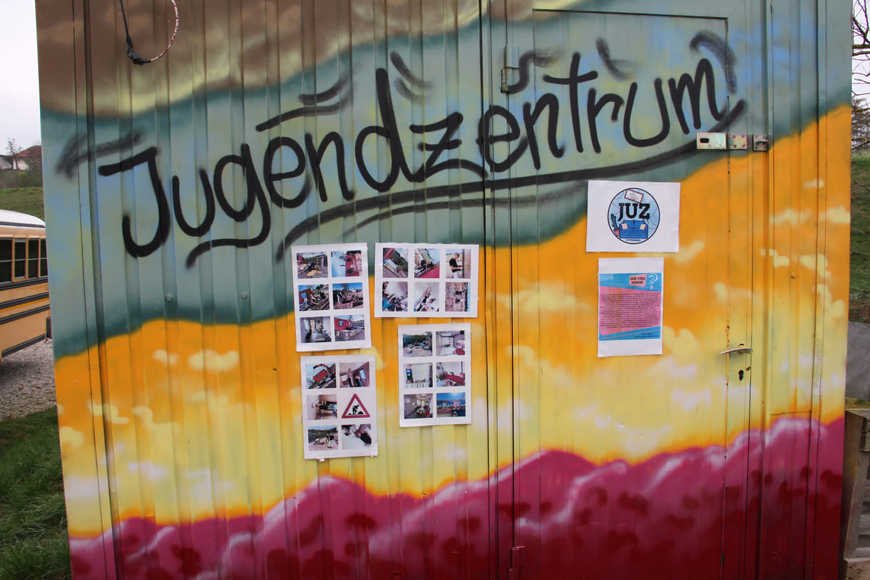 Plakate und Fotos an einer der Container-Wände